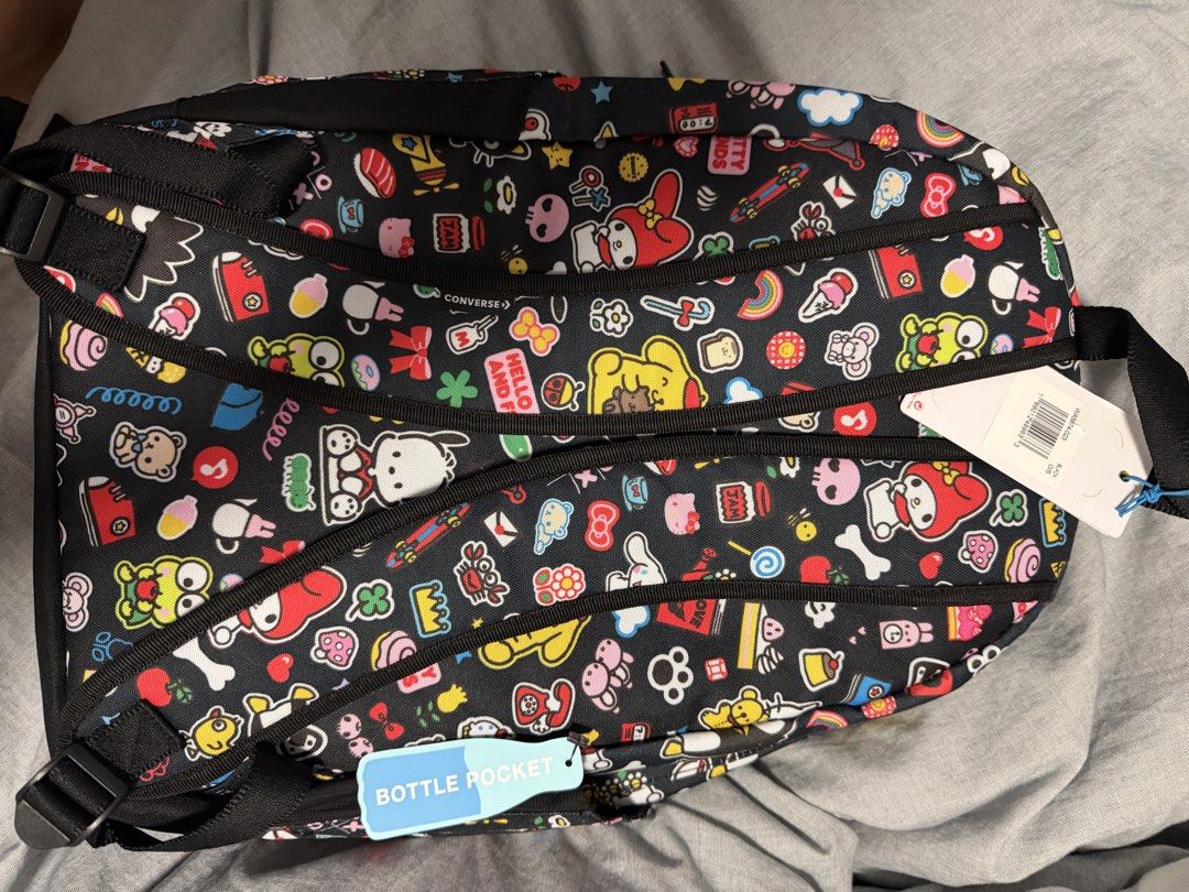 Converse x Hello Kitty and Friends All Over Print Backpack (Category: Backpacks) located in Imus. Submitted by shadracula (Listing ID 1470435862, Image 2). Description: - Brand new with original tags attached - Authentic Converse backpack featuring Kitty and Friends all-over print - Black base with colorful character patches, icons, and Converse All Star logo on front pocket - Equipped with a convenient side bottle pocket and interior slip pocket
