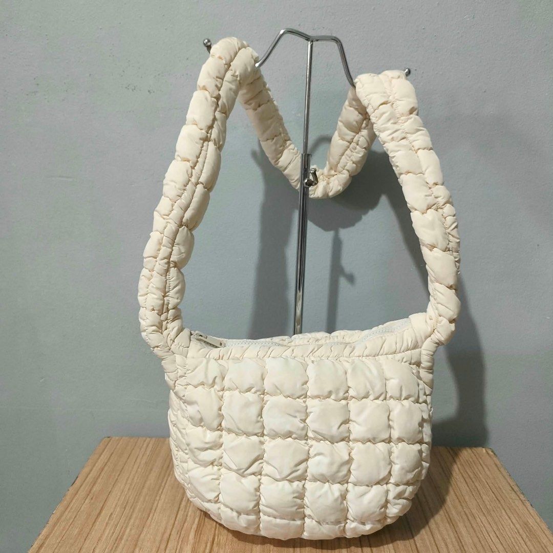 COS Quilted Cloud Mini Shoulder Bag Off White (Category: Shoulder Bags) located in Carmen. Submitted by rr_thrifts (Listing ID 1470397437, Image 1). Description: - Brand: COS - Style: Puffer quilted shoulder bag with matching handles - Material: 100% lightweight synthetic - Closure: Zip top with inner zip pocket and brand label tag - Capacity: Spacious for daily essentials .