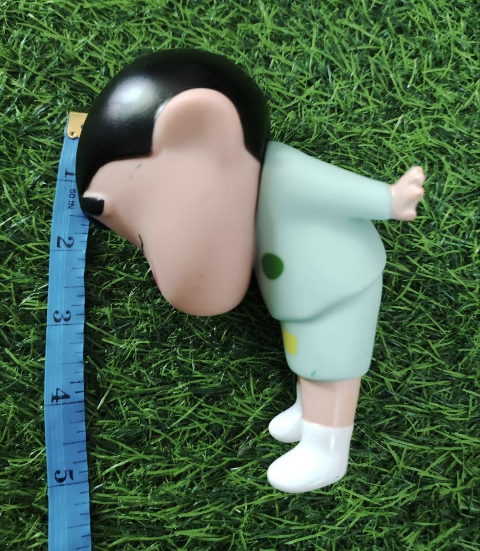 Crayon Shin-chan Figure Sleeping Pajamas (Category: Designer & Blind Box Toys) located in Makati City. Submitted by rare_thrift_stuff (Listing ID 1470359886, Image 3). Description: - Character: Crayon Shin-chan - Design: Sleeping pose wearing light blue pajamas with geometric shapes and pink cheeks - Size: Approximately 4 inches tall - Condition: Pre-loved with minor scuff marks and discoloration on the fingertips/hands (refer to close-up photo) 