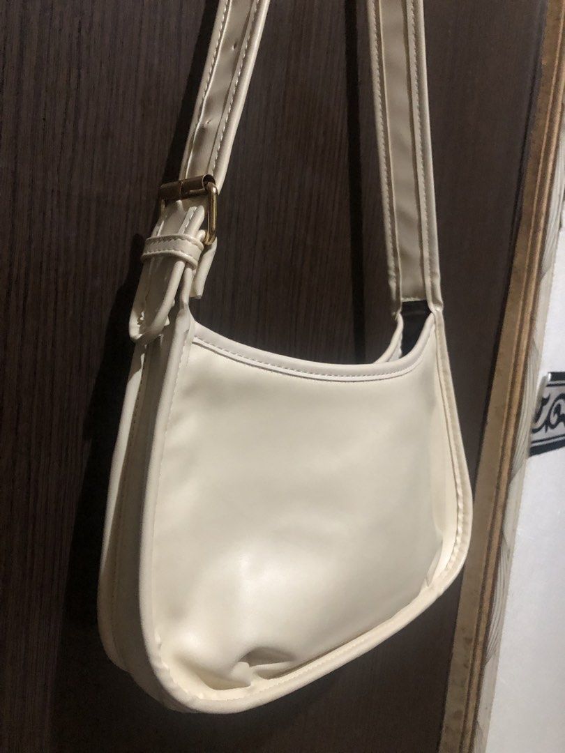 Cream White Shoulder Bag with Front Pocket (Category: Shoulder Bags) located in Valenzuela. Submitted by nixs2722 (Listing ID 1470504709, Image 3). Description: - Color: Cream white - Material: Premium faux leather - Design: Curved, slouchy body with gold-tone metal buckle - Features: Exterior front slip pocket and clean interior lining - Strap: Single adjustable strap - Capacity: Easily fits a standard long wallet - Style: Perfect for casual dai