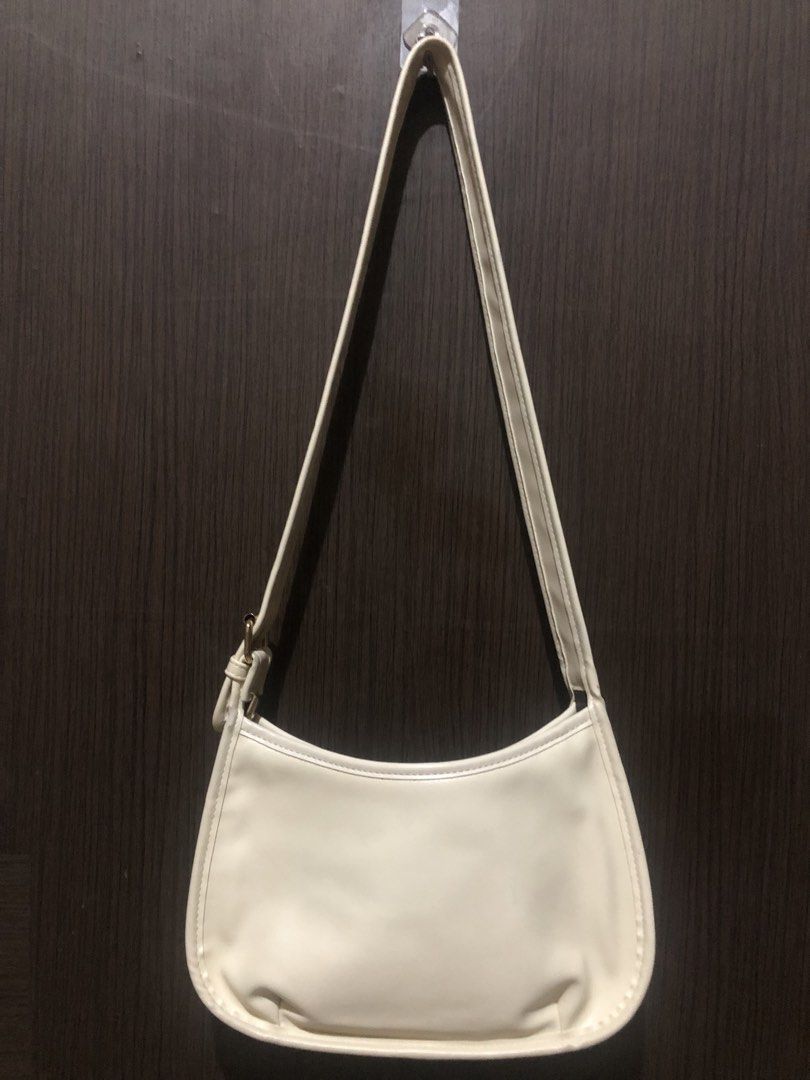 Cream White Shoulder Bag with Front Pocket (Category: Shoulder Bags) located in Valenzuela. Submitted by nixs2722 (Listing ID 1470504709, Image 2). Description: - Color: Cream white - Material: Premium faux leather - Design: Curved, slouchy body with gold-tone metal buckle - Features: Exterior front slip pocket and clean interior lining - Strap: Single adjustable strap - Capacity: Easily fits a standard long wallet - Style: Perfect for casual dai