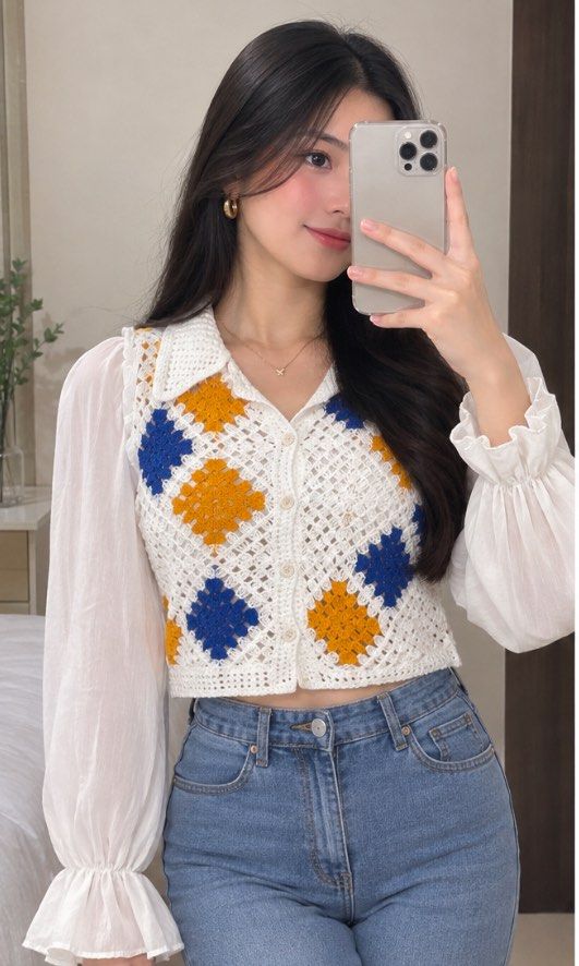 Crochet Granny Square Button-Up Blouse White Blue Yellow (Category: Blouses) located in Tabuk. Submitted by zenwolf-1867 (Listing ID 1470532066, Image 1). Description: - Handmade-style crochet granny square blouse - White base with blue and mustard yellow patches - Collared neckline with front button closure - Long sheer chiffon sleeves with ruffled shoulders and elastic cuffs - Trendy cropped fit - Unique vintage statement piece, perfect for lay
