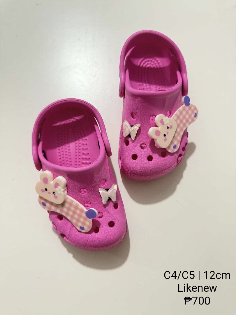 Crocs C4/C5 Pink Kids Clogs Size (Category: Babies & Kids Fashion) located in San Fabian. Submitted by hbrst1998 (Listing ID 1470359078, Image 1). Description: - Size: C4/C5 (Measures 12 cm) - Color: Bright pink with cute rabbit and butterfly charms - Design: Easy slip-on with a secure heel strap - Condition: Like new, only tried on indoors - Soles: Completely clean, no scuffs or marks.