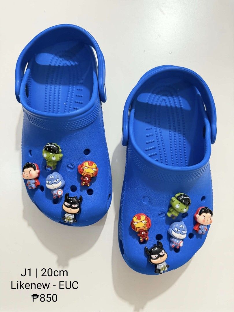 Crocs J1 with Superhero Jibbitz Charms (Category: Babies & Kids Fashion) located in San Fabian. Submitted by hbrst1998 (Listing ID 1470358505, Image 1). Description: - Size: J1 (fits 20cm feet) - Color: Bright blue - Design: Slip-on with pivoting heel straps - Extras: Comes with multiple superhero charms (Iron Man, Batman, Hulk, Superman, Captain America) - Condition: Clean and well-maintained.