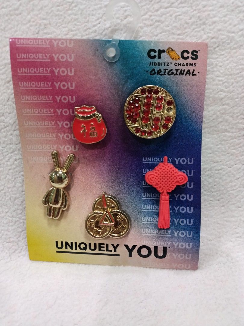 Crocs Jibbitz Charms Original Lunar New Year Pack (Category: Charms) located in Manila. Submitted by jollynest24 (Listing ID 1470491295, Image 1). Description: - 100% Authentic Crocs Jibbitz Lunar New Year pack - Brand new, still attached to original retail backing card with hanging hook - Includes 4 festive charms: shiny gold rabbit, red money bag, rhinestone gold piece, and pink Chinese knot tassel - Comes with an extra charm featuring 3 stacke