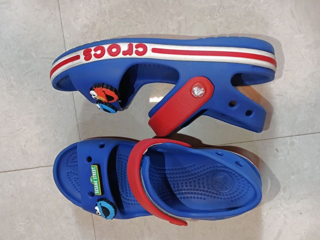 Crocs Sandals C13 (Category: Babies & Kids Fashion) located in Quezon City. Submitted by waemierrie (Listing ID 1470512797, Image 1). Description: Original Crocs C13 Sandals Fits approx 19cm Comes with 4 original Sesame Street Jibbitz Signs of usage ~ scratches and dirt on the band, minimal outsole drags Blue and red Crocs sandals featuring Sesame Street characters Elmo and Cookie Monster Jibbitz charms. Adjustable red heel strap and white midsol