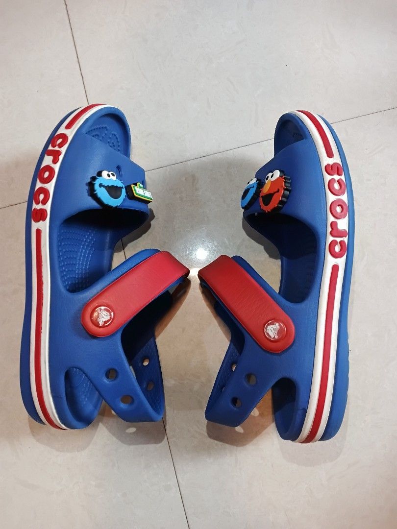 Crocs Sandals C13 (Category: Babies & Kids Fashion) located in Quezon City. Submitted by waemierrie (Listing ID 1470512797, Image 3). Description: Original Crocs C13 Sandals Fits approx 19cm Comes with 4 original Sesame Street Jibbitz Signs of usage ~ scratches and dirt on the band, minimal outsole drags Blue and red Crocs sandals featuring Sesame Street characters Elmo and Cookie Monster Jibbitz charms. Adjustable red heel strap and white midsol