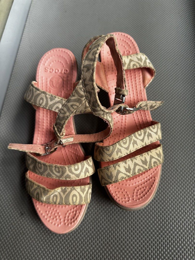 Crocs Wedge Sandals Patterned Strap Pink Women Size 6 (Category: Wedges) located in Digos. Submitted by venusacaro13427 (Listing ID 1470432576, Image 1). Description: - Brand/Style: Crocs wedge sandals - Size: Women's US 6 - Design: Pink textured footbed with patterned beige fabric upper and ankle straps - Closure: Adjustable side buckle - Heel: Brown wedge with great traction - Condition: Minor wear on bottom soles from previous use - Features: 