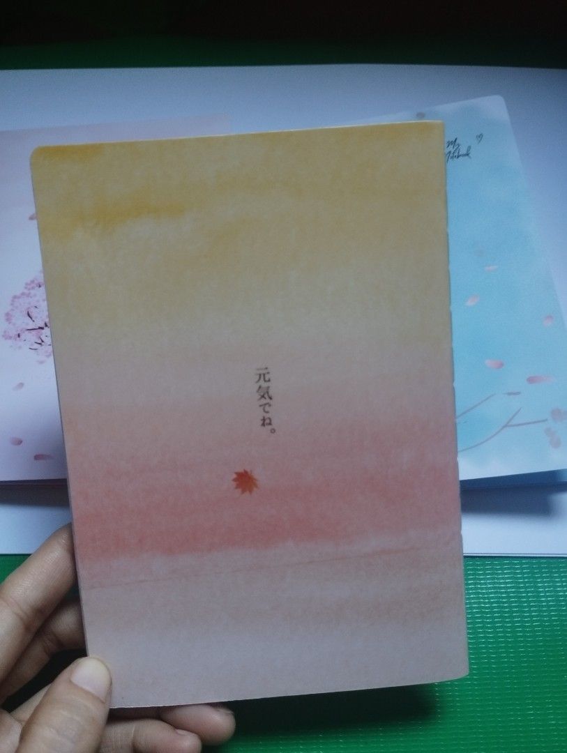 Cute Gradient Autumn Aesthetic Notebook Diary Journal (Category: Stationery & School Supplies) located in San Mateo. Submitted by diana_01.tree (Listing ID 1470351396, Image 2). Description: - Design: Gradient orange & yellow cover with aesthetic autumn girl art and Japanese text details - Inside Pages: Features lovely watercolor headers with cute maple leaf graphics - Condition: Brand new, clean pages, ready for writing - Best For: Journaling, d