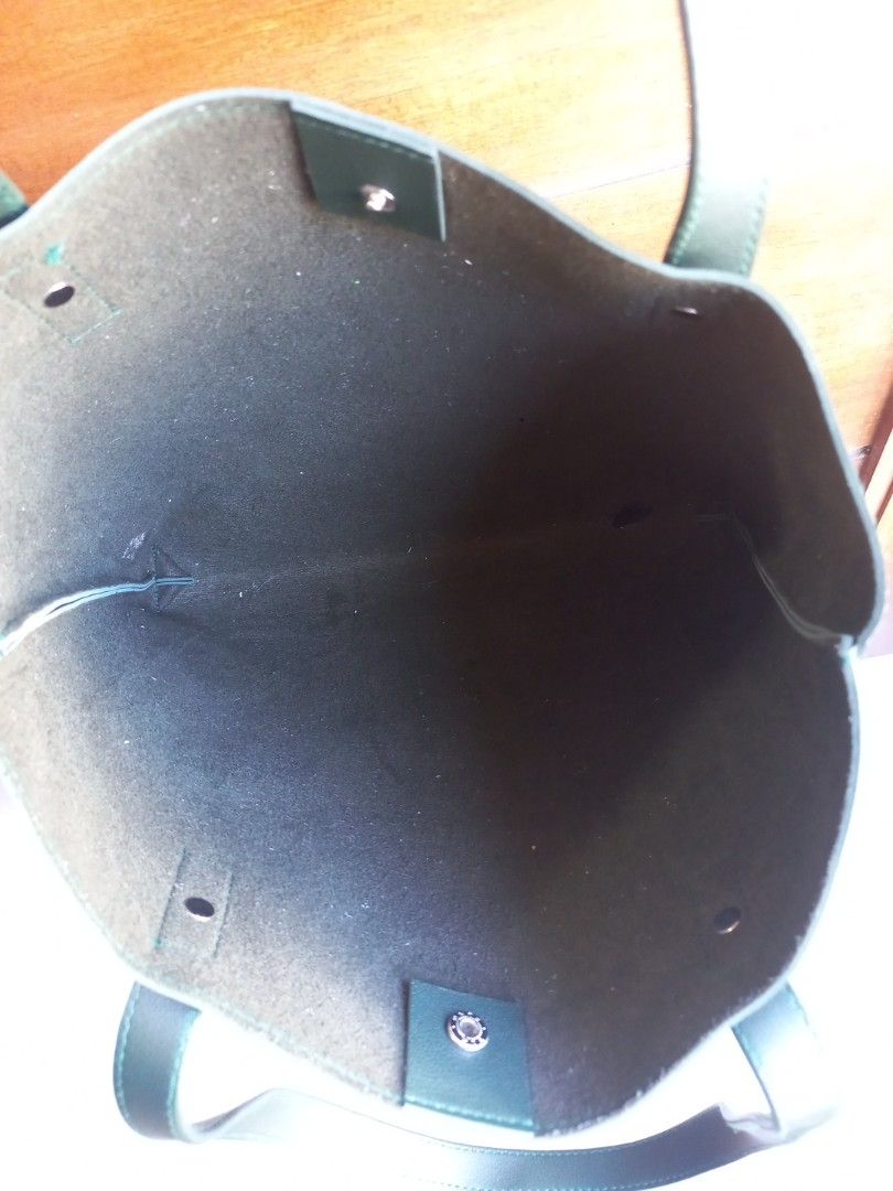 Dark Green Leather Tote Bag (Category: Tote Bags) located in Rizal. Submitted by mayra74 (Listing ID 1470356182, Image 1). Description: - Color: Dark green - Material: Leather - Style: Minimalist everyday/work tote - Design: Single large compartment with clean interior - Closure: Magnetic snap button on side tab - Capacity: Easily fits laptop, books, and daily essentials - Condition: Clean inside and out with secure handles.