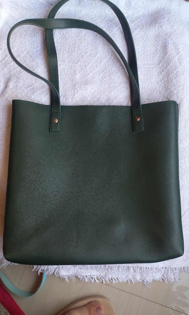 Dark Green Leather Tote Bag (Category: Tote Bags) located in Rizal. Submitted by mayra74 (Listing ID 1470356182, Image 2). Description: - Color: Dark green - Material: Leather - Style: Minimalist everyday/work tote - Design: Single large compartment with clean interior - Closure: Magnetic snap button on side tab - Capacity: Easily fits laptop, books, and daily essentials - Condition: Clean inside and out with secure handles.