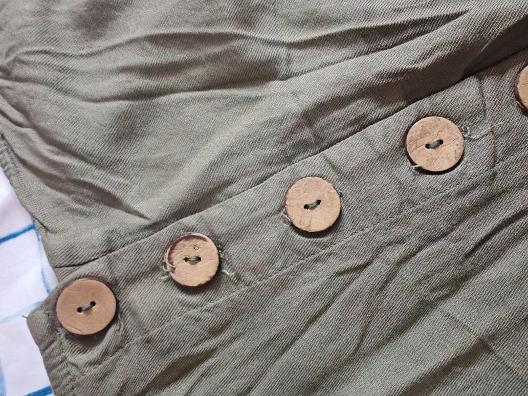 Derek Heart Olive Green Button Front Romper Size M (Category: Rompers) located in Paranaque City. Submitted by MLandCobyApple (Listing ID 1470374985, Image 2). Description: - Brand: Derek Heart - Size: Medium (Tag attached) - Color: Olive green - Material: Lightweight, textured fabric - Features: Adjustable tie straps, decorative wooden front buttons, functional side pockets - Condition: Brand new with tags - Style: Casual, easy throw-on piece fo