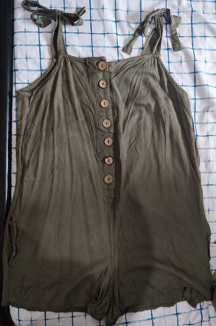 Derek Heart Olive Green Button Front Romper Size M (Category: Rompers) located in Paranaque City. Submitted by MLandCobyApple (Listing ID 1470374985, Image 1). Description: - Brand: Derek Heart - Size: Medium (Tag attached) - Color: Olive green - Material: Lightweight, textured fabric - Features: Adjustable tie straps, decorative wooden front buttons, functional side pockets - Condition: Brand new with tags - Style: Casual, easy throw-on piece fo
