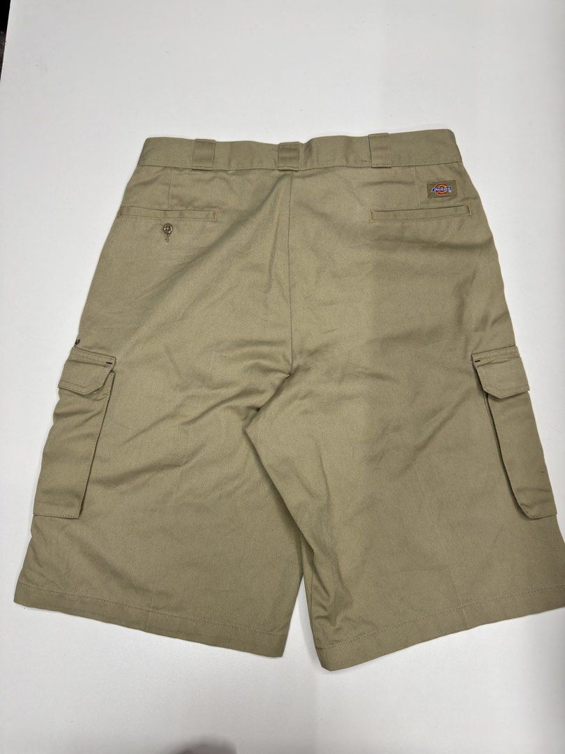 Dickies Khaki Cargo Shorts (Category: Shorts) located in Bustos. Submitted by thenlnclot60500 (Listing ID 1470438135, Image 2). Description: - Brand: Dickies - Item: Cargo Shorts - Color: Khaki Beige - Material: Heavy-duty cotton twill fabric - Features: Multiple utility pockets, side cargo pockets, buttoned back pockets, and small logo patch - Condition: Pre-owned with visible stains and marks on the front and leg areas - Perfect for casual wear