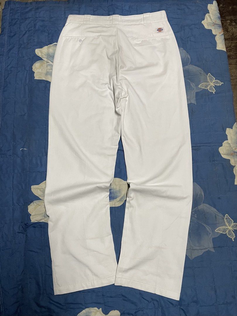 Dickies White Casual Pants (Category: Trousers) located in Manila. Submitted by chawmichael (Listing ID 1470473775, Image 2). Description: - Brand: Dickies - Color: Classic solid white - Fit: Straight leg cut with crisp front creases - Details: Sturdy workwear fabric, standard belt loops - Pockets: Back welt pockets (left with button closure, right with signature Dickies logo tag) - Style: Minimalist streetwear staple Good as new Dimes W 36 L 46 