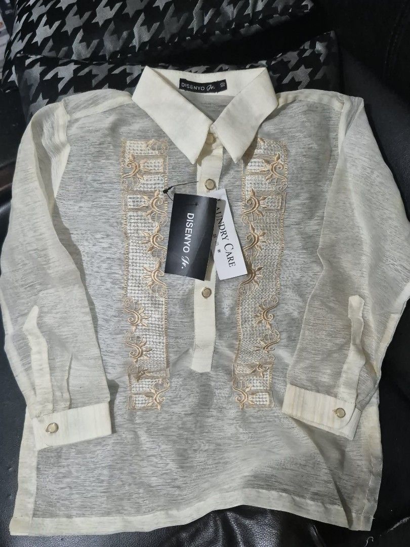Disenyo Jr. Barong Tagalog (Category: Formal Shirts) located in Quezon City. Submitted by kctheexplorer05 (Listing ID 1470533121, Image 1). Description: Disenyo Jr. Barong Tagalog from Robinsons Department Store. Traditional long-sleeve formal wear. Detailed embroidery panels down the front. Classic pointed collar, button placket, and button cuffs. Cream-colored sheer fabric. Original tags still attached with retail price of P899.00. Size 10 tag 