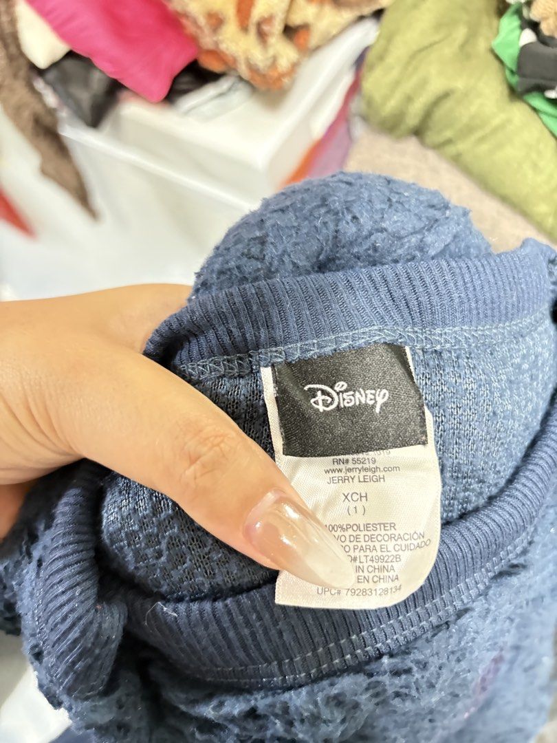 Disney Stitch Fuzzy Blue Sequined Pullover Sweater (Category: Coats, Jackets and Outerwear) located in General Trias. Submitted by crissy9053136 (Listing ID 1470487626, Image 2). Description: - Brand: Jerry Leigh (Disney) - Size: XCH - Color: Dark blue - Design: Large blue & purple sequin Stitch graphic on the front - Material: Soft, warm fleece-like fabric - Details: Ribbed crewneck, cuffs, and hem - Condition: Brand new with tag attached.