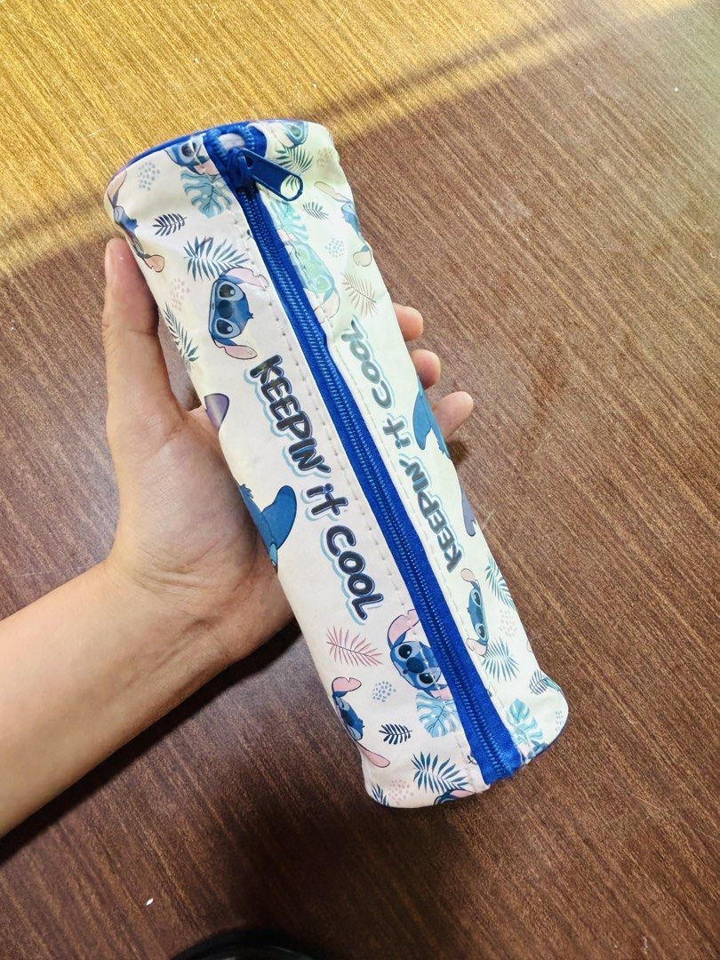 Disney Stitch Tropical Design Pencil Case Keepin It Cool (Category: Stationery & School Supplies) located in Manila. Submitted by starbalesukandjapansurplus (Listing ID 1470555670, Image 2). Description: - Design: Cute Stitch character with tropical leaf print and 'Keepin it cool' text - Color/Closure: Blue zipper closure down the middle - Shape: Roomy cylinder design, perfect for pens and stationery - Condition: Shows minor wear marks inside fro
