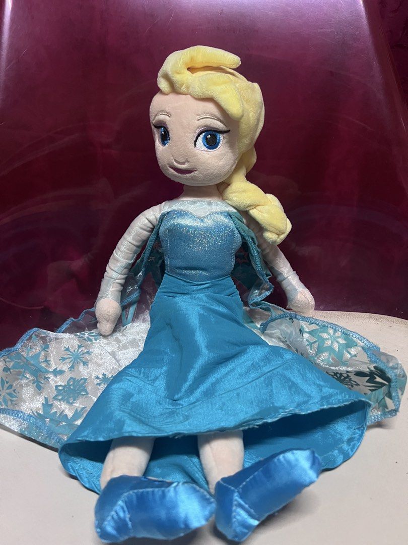 Disney Store Frozen Elsa Plush Doll (Category: Plushies & Soft Toys) located in Bulacan. Submitted by haven_plushie_dolls.888 (Listing ID 1470428781, Image 1). Description: - 100% Authentic Disney Store Elsa plush toy from Frozen - Features her iconic blue dress with sparkly snowflake cape and braided blonde hair - Made with soft, huggable fabric - great for kids or collectors - Official tag attached underneath the dress.