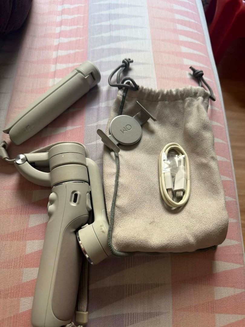 DJI OM 5 Smartphone Gimbal Stabilizer (Category: Gimbals & Stabilizers ) located in Manila. Submitted by johndytaga02095 (Listing ID 1470533762, Image 3). Description: - Model: DJI OM 5 (Sunset White) - Condition: Excellent, complete set - Includes: Magnetic phone clamp, mini tripod stand, power cable, and storage pouch - Features: Portable design, perfect for smooth video shots and phone vlogging - Reason for selling: Decluttering gear.