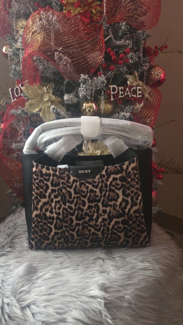 DKNY Leopard Print Handbag (Category: Luxury Bags & Wallets) located in Cabanatuan. Submitted by belle_1013 (Listing ID 1470424507, Image 1). Description: - Brand: DKNY - Condition: Brand new, unused with protective packaging and handle wrapping still intact - Design: Structured silhouette combining textured black leather and trendy leopard print panels - Details: Distinctive metal logo badge on the front closure tab with solid black side gussets
