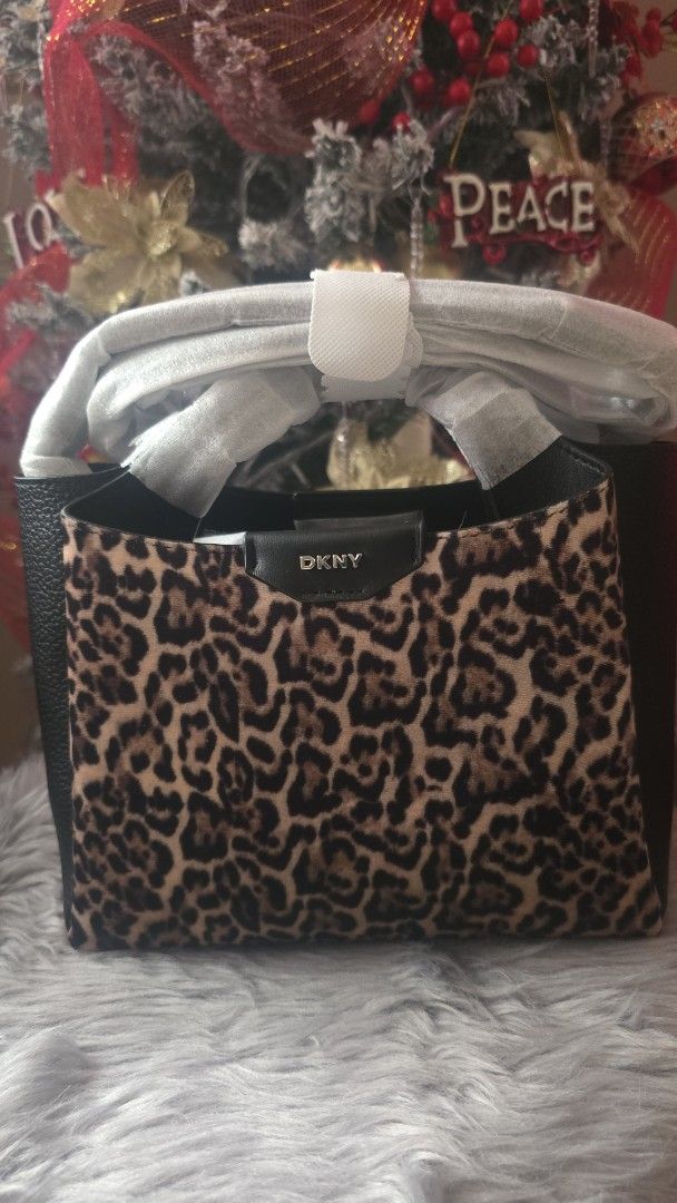 DKNY Leopard Print Handbag (Category: Luxury Bags & Wallets) located in Cabanatuan. Submitted by belle_1013 (Listing ID 1470424507, Image 2). Description: - Brand: DKNY - Condition: Brand new, unused with protective packaging and handle wrapping still intact - Design: Structured silhouette combining textured black leather and trendy leopard print panels - Details: Distinctive metal logo badge on the front closure tab with solid black side gussets