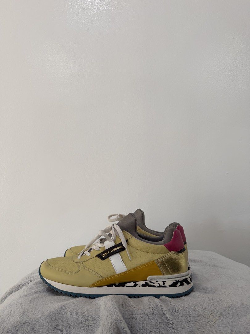 Dolce & Gabbana Multicolor Leather Sneakers (Category: Sneakers & Footwear) located in Manila. Submitted by escarchame98247 (Listing ID 1470490237, Image 2). Description: Dolce & Gabbana designer sneakers in yellow leather with pink, gold, and white panels. Black and white cow print detail along the midsole. Navy blue ridged rubber outsole with embossed branding. White laces and padded grey tongue with brand label. Bold colorblock design combinin