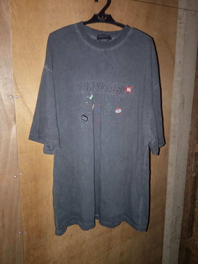 DONOTTAG Graphic Oversized T-Shirt (Category: Tshirts & Polo Shirts ) located in Carmen. Submitted by kyntmiras_thrift (Listing ID 1470456865, Image 2). Description: - Brand: DONOTTAG - Color: Dark grey with washed faded look - Fit: Relaxed, oversized - Material: Comfortable cotton - Design: Large embossed chest logo with colorful splatter graphics and small embroidered patches - Condition: Clean inside and out, ready to wear.
