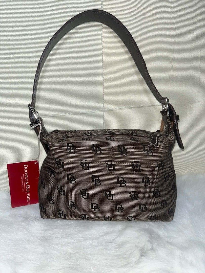 Dooney & Bourke Brown Canvas Mini Sac Shoulder Bag (Category: Luxury Bags & Wallets) located in Imus. Submitted by maria_pilayo (Listing ID 1470438817, Image 2). Description: - Brand: Dooney & Bourke - 💯 % Authentic - Material: Brown monogram canvas with dark brown leather straps - Hardware: Silver-tone - Dimensions: 26cm length x 17cm height (Compact daily size) - Features: Top zipper closure, iconic blue duck logo charm - Condition: Brand new 