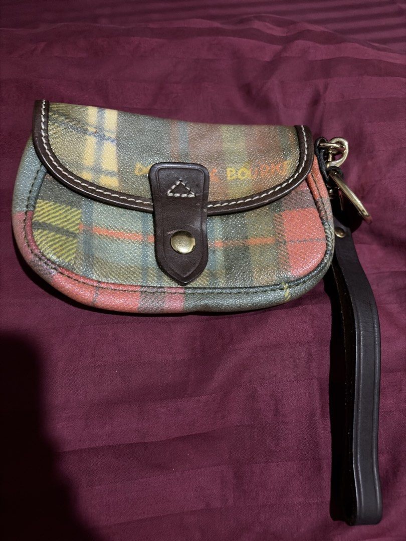 Dooney & Bourke Plaid Wristlet (Category: Luxury Bags & Wallets) located in Las Pinas. Submitted by ces0427 (Listing ID 1470470764, Image 1). Description: - Authentic Dooney & Bourke plaid wristlet wallet - Multicolor tartan pattern with stylish dark brown leather trim - Secure gold-tone snap closure - Includes a matching leather wrist strap for easy carrying - Features the classic blue duck logo charm - Compact and convenient size for cards, cas