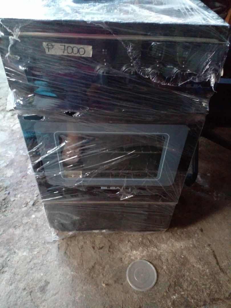 Elba gas range with oven (Category: Cookers) located in Manila. Submitted by wisegem-231b (Listing ID 1470400769, Image 3). Description: - Brand: Elba - Type: Gas range and oven unit - Color: Elegant black finish - Condition: Brand new with protective plastic film wrap still intact - Features: Multiple top burners and front-loading oven with a glass window door - Price: ₱7,000 (tag attached).