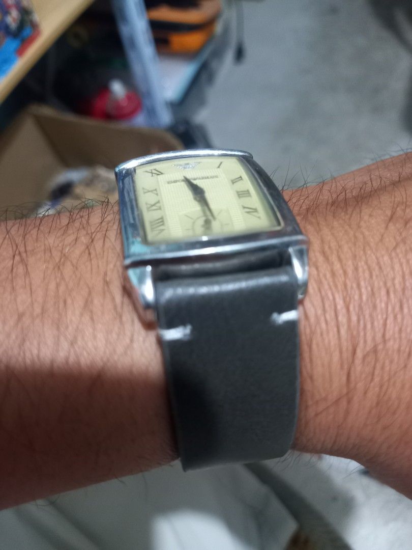 Emporio Armani Rectangular Roman Dial Leather Strap Watch (Category: Women's Watches) located in Subic. Submitted by regiegabriel29 (Listing ID 1470373827, Image 3). Description: - Brand: Emporio Armani - Style: Classic rectangular dress watch - Dial: Textured cream with Roman numerals and sub-dial at 3 o'clock - Case: Silver-tone stainless steel - Strap: Dark grey leather with contrast white stitching and standard buckle clasp - Condition: Pre-l