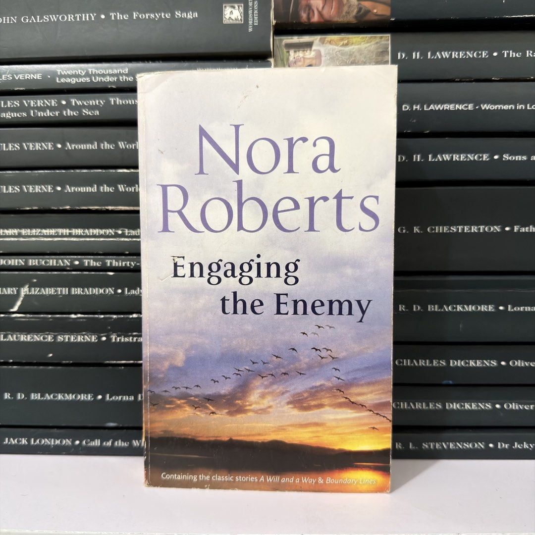 Engaging the Enemy by Nora Roberts Novel (Category: Storybooks) located in Lingayen. Submitted by readwjane (Listing ID 1470479927, Image 1). Description: - Title: Engaging the Enemy by Nora Roberts - Includes two classic stories: A Will and A Way & Boundary Lines - Format: Paperback - Cover art: Birds flying over a sunset landscape with water - Condition: Normal shelf wear visible on edges and corners - Ships securely from the Philippines!.