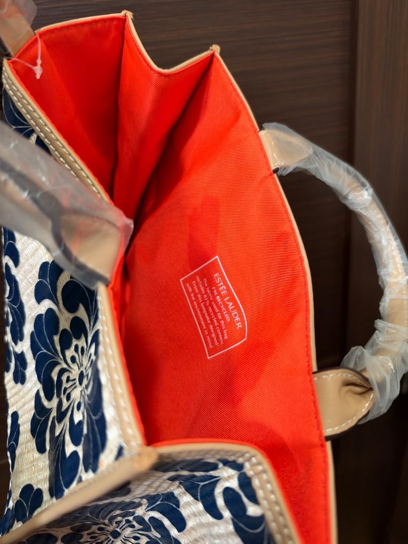 Estee Lauder Blue Floral Structured Tote Bag (Category: Tote Bags) located in Manila. Submitted by itspao457 (Listing ID 1470352210, Image 3). Description: - Brand: Estee Lauder - Design: Blue and cream floral pattern with beige faux leather trim - Interior: Vibrant orange fabric lining with a recycled content inner label Perfect for Summer/Beach/Filipiñana Themed OOTD.