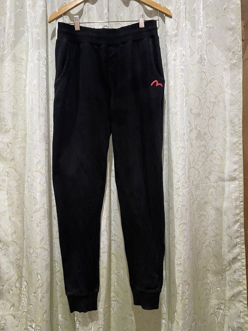 Evisu Black Graphic Sweatpants Size 100 L (Category: Joggers) located in Iligan City. Submitted by goldielooks143 (Listing ID 1470477695, Image 2). Description: - Brand: Evisu - Color: Black - Size: 100 (Large) - Design: White & red graphic print on back legs with small red logo embroidery near the front pocket - Comfort: Soft fleece lining on the inside - Fit: Drawstring waist and ribbed ankle cuffs - Model Code: EQ5UZPL - DM for measurements or