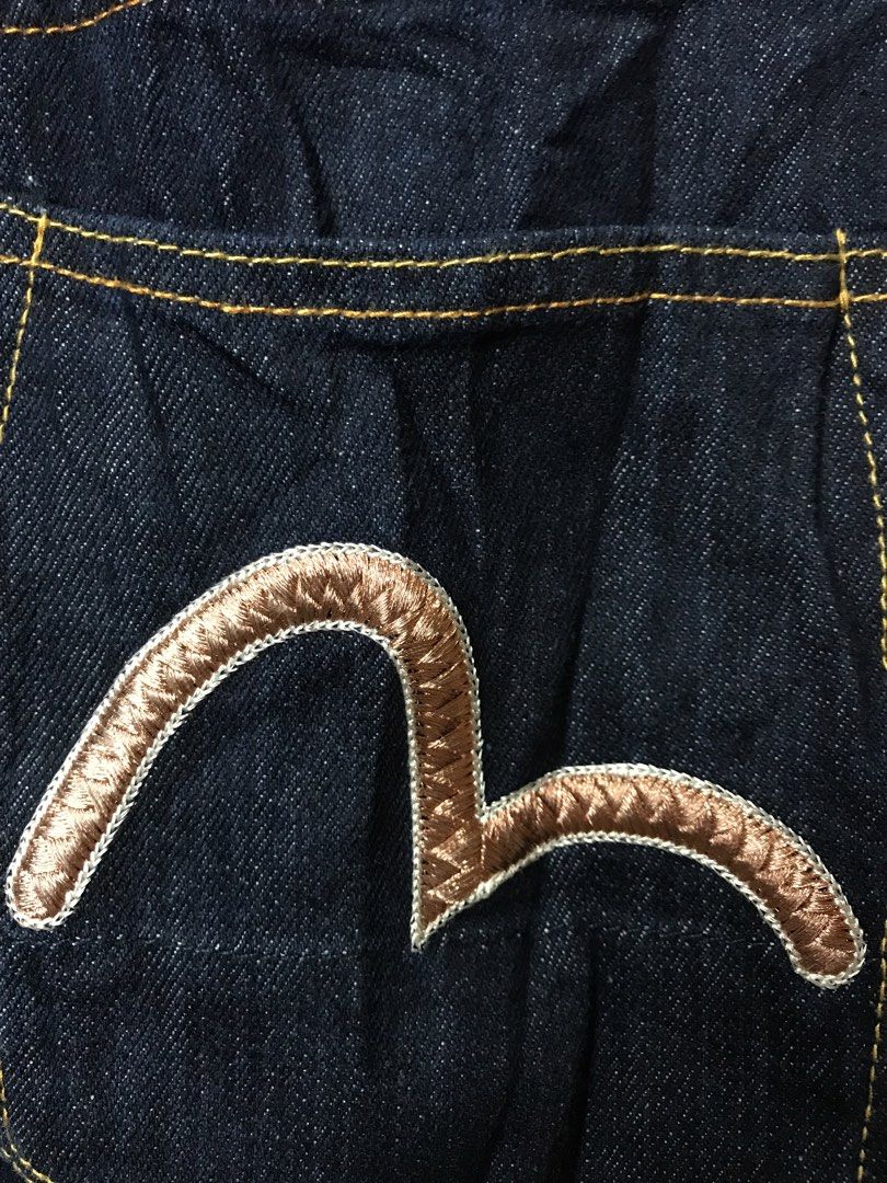 Evisu Dark Wash Denim Jeans (Category: Jeans) located in Aloguinsan. Submitted by jayhooukay (Listing ID 1470475208, Image 2). Description: - Brand: Evisu - Wash: Dark wash, premium heavy denim - Fit: Straight leg - Details: Classic button fly and contrast stitching - Back Pockets: Distinctive bronze-tone embroidered gulls - Cuffs: Selvedge denim with red, white, and navy ticking - Branding: Leather patch on the back waistband.