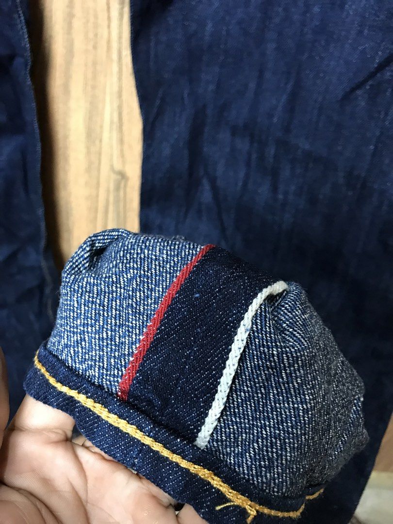 Evisu Dark Wash Denim Jeans (Category: Jeans) located in Aloguinsan. Submitted by jayhooukay (Listing ID 1470475208, Image 3). Description: - Brand: Evisu - Wash: Dark wash, premium heavy denim - Fit: Straight leg - Details: Classic button fly and contrast stitching - Back Pockets: Distinctive bronze-tone embroidered gulls - Cuffs: Selvedge denim with red, white, and navy ticking - Branding: Leather patch on the back waistband.