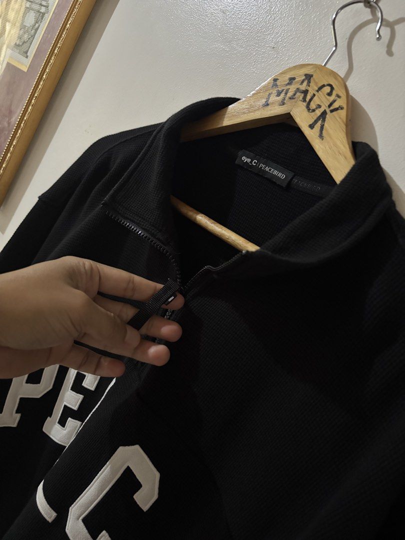 Eye_C Peacebird Black Quarter Zip Sweatshirt (Category: Coats, Jackets and Outerwear) located in Kalibo. Submitted by mack29 (Listing ID 1470351502, Image 2). Description: - Brand: Eye_C Peacebird - Color: Black with large white embroidered 'PEACE' lettering across the chest - Material: Comfortable waffle-knit textured fabric - Design: High collar with zipper closure and black pull tab, small upper back logo detail - Fit: Ribbed cuffs and hem - C