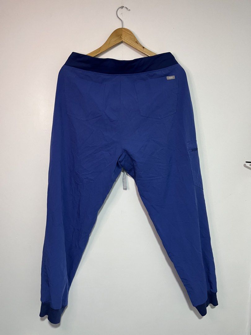 FIGS Technical Collection Scrub Joggers Blue Size L (Category: Joggers) located in Dasmarinas. Submitted by thriftedbygii (Listing ID 1470532986, Image 3). Description: - Brand: FIGS Technical Collection - Color: Blue with contrast dark waistband and cuffs - Fit: Jogger style with secure drawstring waist and ribbed ankle cuffs - Storage: Multiple functional pockets for tools, phone, and essentials - Fabric: Ultra-soft stretch material designed fo