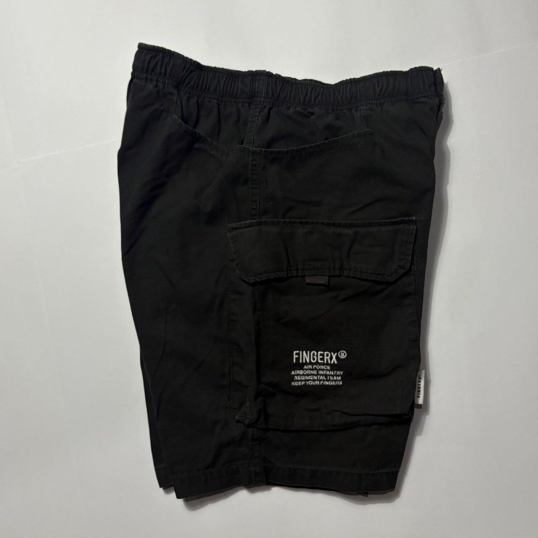 Fingercrox Military Cargo Shorts Black (Category: Shorts) located in San Fernando. Submitted by lumang_gamit (Listing ID 1470398016, Image 3). Description: - Brand/Style: Fingercrox military-style black cargo shorts - Material: Heavy-duty cotton fabric - Waistband: Comfortable elastic waistband with button closure - Storage: Multiple utility pockets on the sides for extra storage - Details: Graphic text print on left cargo pocket and woven milita