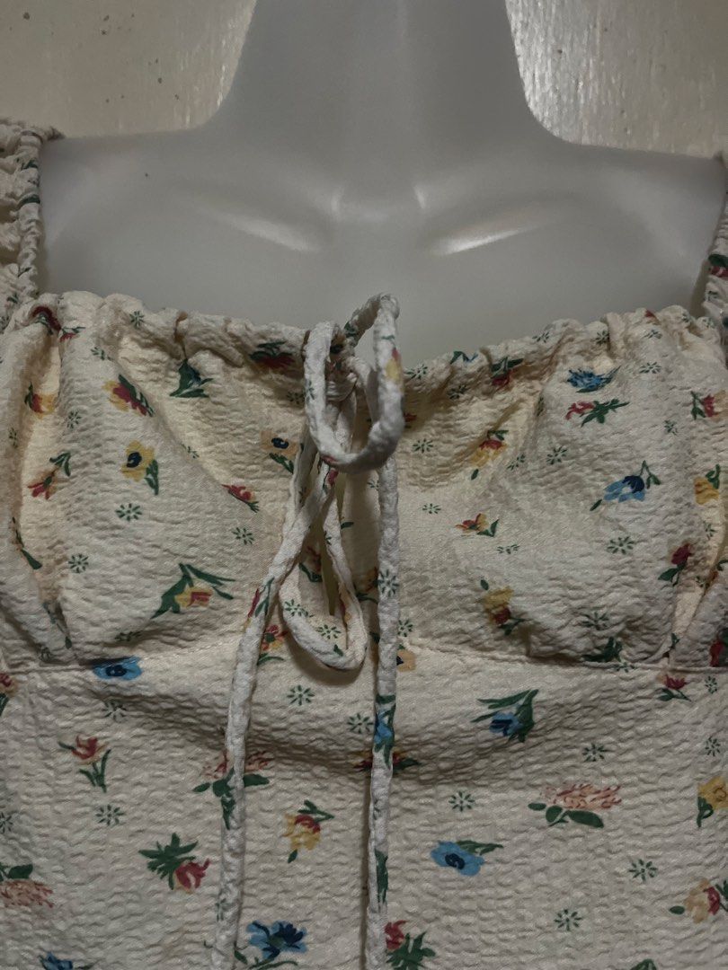 Floral Long Sleeve Crop Top with Drawstring (Category: Longsleeves) located in Tabuk. Submitted by zenwolf-1867 (Listing ID 1470531887, Image 3). Description: - Color: Cream with multicolored floral print - Fit: Crop top, hits right above the waist - Sleeves: Long balloon sleeves with ruffled cuffs - Neckline: Square neckline with front drawstring tie - Details: Elastic shoulders and textured crinkled fabric.