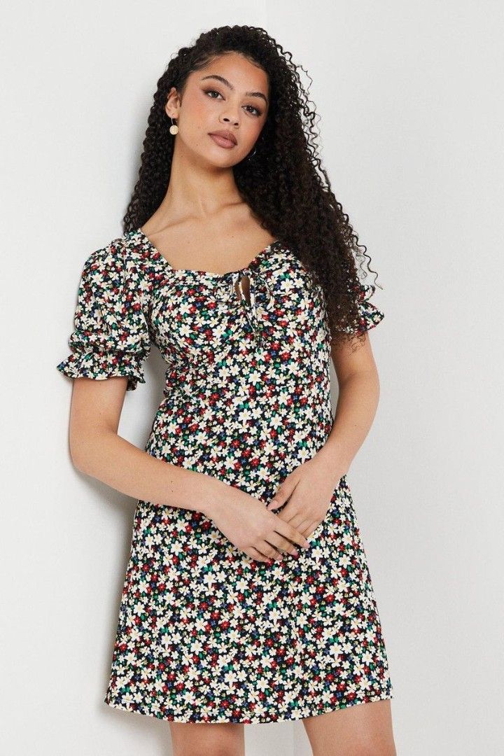 Floral Print Square Neck Tie-Front Mini Dress (Category: Dresses) located in Paranaque City. Submitted by calm_youngstore7 (Listing ID 1470441682, Image 3). Description: - Style: Black floral mini dress - Neckline: Sweetheart with front tie detail - Sleeves: Short puff sleeves with ruffled cuffs - Fit: Fitted bodice with a gently flared hem - Occasion: Perfect for warm weather and casual daytime outings - Condition: Brand new / Excellent.