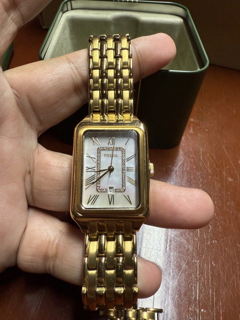 Fossil Gold Tone Rectangular Women's Watch with Box (Category: Women's Watches) located in Paranaque City. Submitted by engrmike (Listing ID 1470350231, Image 3). Description: - Brand: Fossil women's watch - Color/Material: Elegant gold-tone stainless steel link bracelet with deployment clasp - Dial: Rectangular face featuring classic Roman numerals, date window, and sparkling crystal accents - Inclusions: Comes with extra links and the original 
