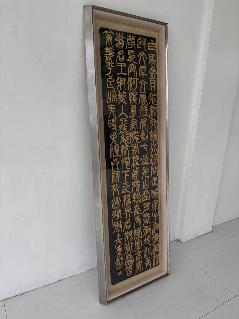 Framed Chinese Seal Script Calligraphy Art Piece (Category: Frames & Pictures) located in Manila. Submitted by roveeeeelen_06 (Listing ID 1470508596, Image 2). Description: - Large vertical Chinese calligraphy art in traditional seal script - Striking gold characters on a dark textured background - Protected by glass inside a heavy, durable metal frame - Green backing with an authentic Japanese paper label and red stamp - Ready to hang and elevat