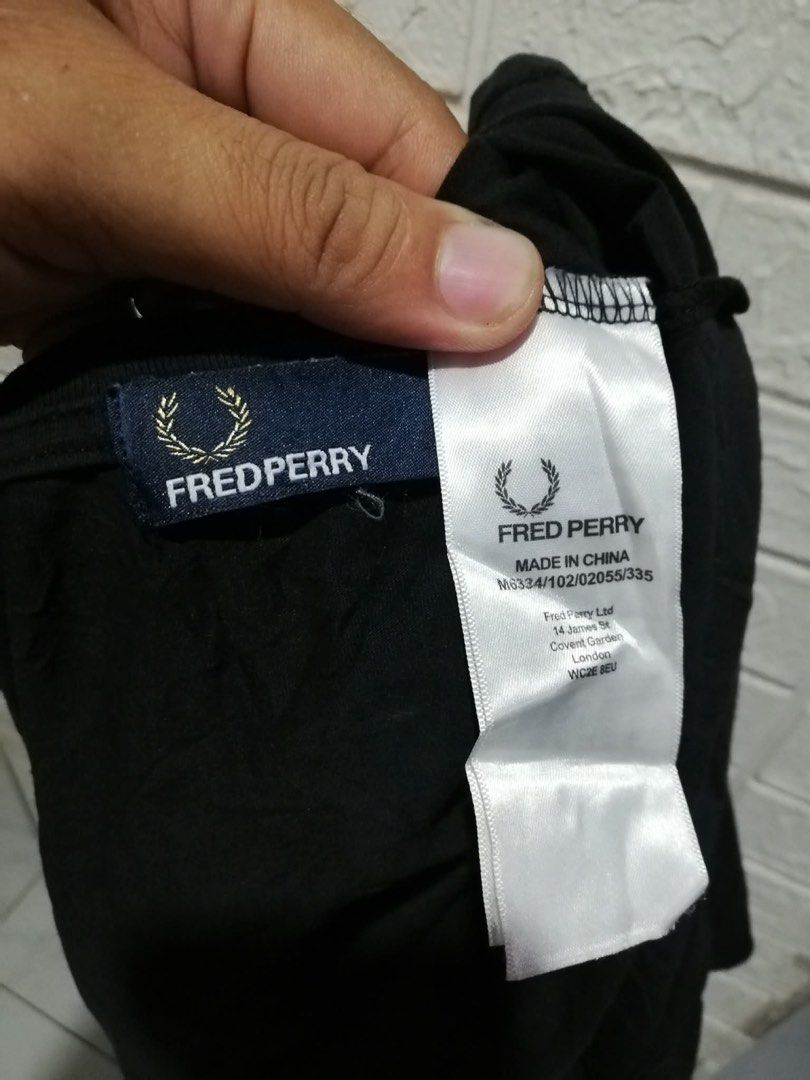 Fred Perry Black T-Shirt with White Patch Logo (Category: Tshirts & Polo Shirts ) located in Rizal. Submitted by tiangarcia02 (Listing ID 1470521465, Image 2). Description: Black crew neck t-shirt from Fred Perry. Short sleeves, standard fit. Features a white square patch on the left chest with the embroidered laurel wreath logo. Inside neck tag and long care label attached at the side seam. Made in China. Clean condition overall, comfortable cot