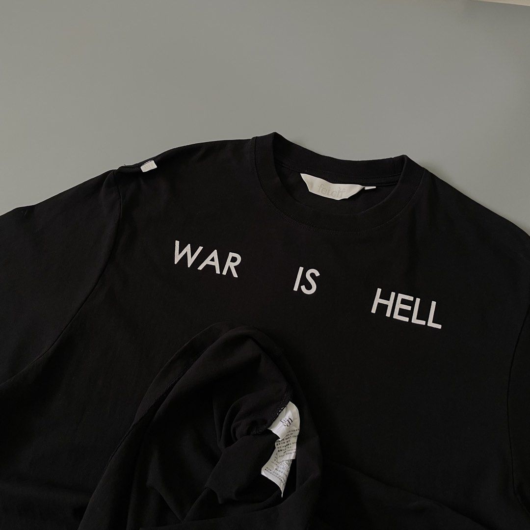Ftclh Black War Is Hell Flame Graphic T-Shirt (Category: Tshirts & Polo Shirts ) located in Manila. Submitted by allthrift07 (Listing ID 1470400694, Image 3). Description: - Brand: Ftclh - Color: Black - Material: Clean cotton build with standard crew neckline - Front: 'WAR IS HELL' text printed in white across upper chest - Back: Large flaming billiard ball graphic with gradient red, orange, and yellow flames - Details: Small white branding logo
