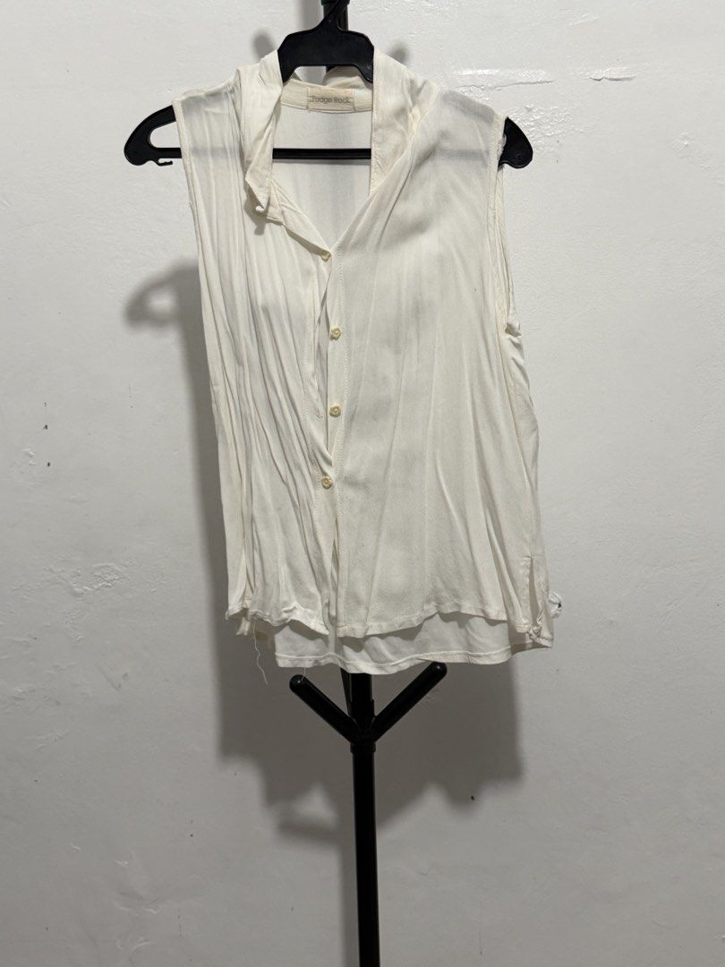Fudge Rock White Sleeveless Button-Down Layered Blouse (Category: Sleeveless) located in Mandaluyong City. Submitted by jdflores17 (Listing ID 1470455558, Image 1). Description: - Brand: Fudge Rock - Style: Sleeveless button-down shirt with classic collar - Color: White - Material: Lightweight fabric - Design Features: Layered hem and front buttons - Condition: Clean overall - Styling Tip: Easy to pair with shorts or jeans for warm weather.