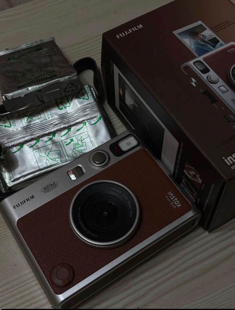 Fujifilm Instax Mini Evo Hybrid Instant Camera (Category: Cameras) located in Cavite. Submitted by adsartes (Listing ID 1470425338, Image 2). Description: - Model: Fujifilm Instax Mini Evo Hybrid Instant Camera - Color: Brown and Silver - Condition: Fully assembled and ready to shoot - Inclusions: Original retail box, shoulder strap, and 2 unopened packs of instant film foil packages - Features: Hybrid setup that lets you shoot digitally and prin