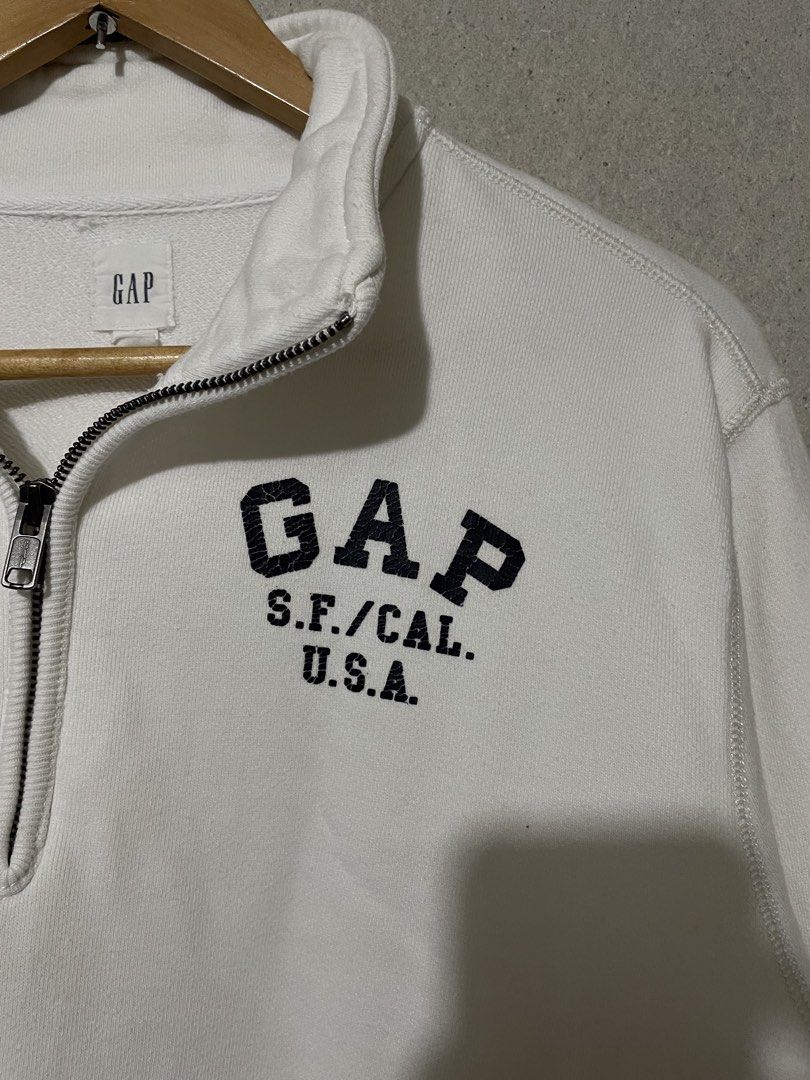 Gap Half Zip Sweatshirt White Size L (Category: Coats, Jackets and Outerwear) located in Antipolo. Submitted by jemiruxd (Listing ID 1470462649, Image 2). Description: - Brand/Style: White Gap half-zip sweatshirt with a stand-up collar - Graphic: Bold black GAP S.F./CAL. U.S.A. print on the chest - Size: L (tag on collar) - Material: 100% cotton - Details: Ribbed cuffs and hem, smooth-working metal zipper - Condition: Clean white fabric, classic 