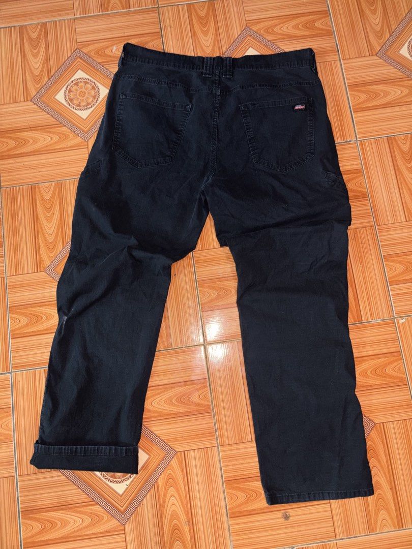 Genuine Dickies Black Cargo Work Pants (Category: Trousers) located in Polomolok. Submitted by rrthrift (Listing ID 1470503230, Image 2). Description: - Brand: Genuine Dickies - Color: Dark Navy Blue Size 36 length 41 - Material: Heavy-duty cotton with ripstop texture - Pockets: Multiple utility pockets on sides and back - Closure: Standard button and zipper fly - Style: Classic utility workwear.